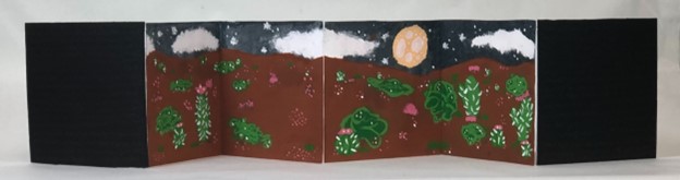 An accordian book featuring a desert scene at night